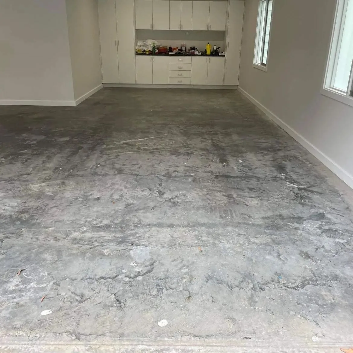 Garage floor before: bare, stained concrete slab