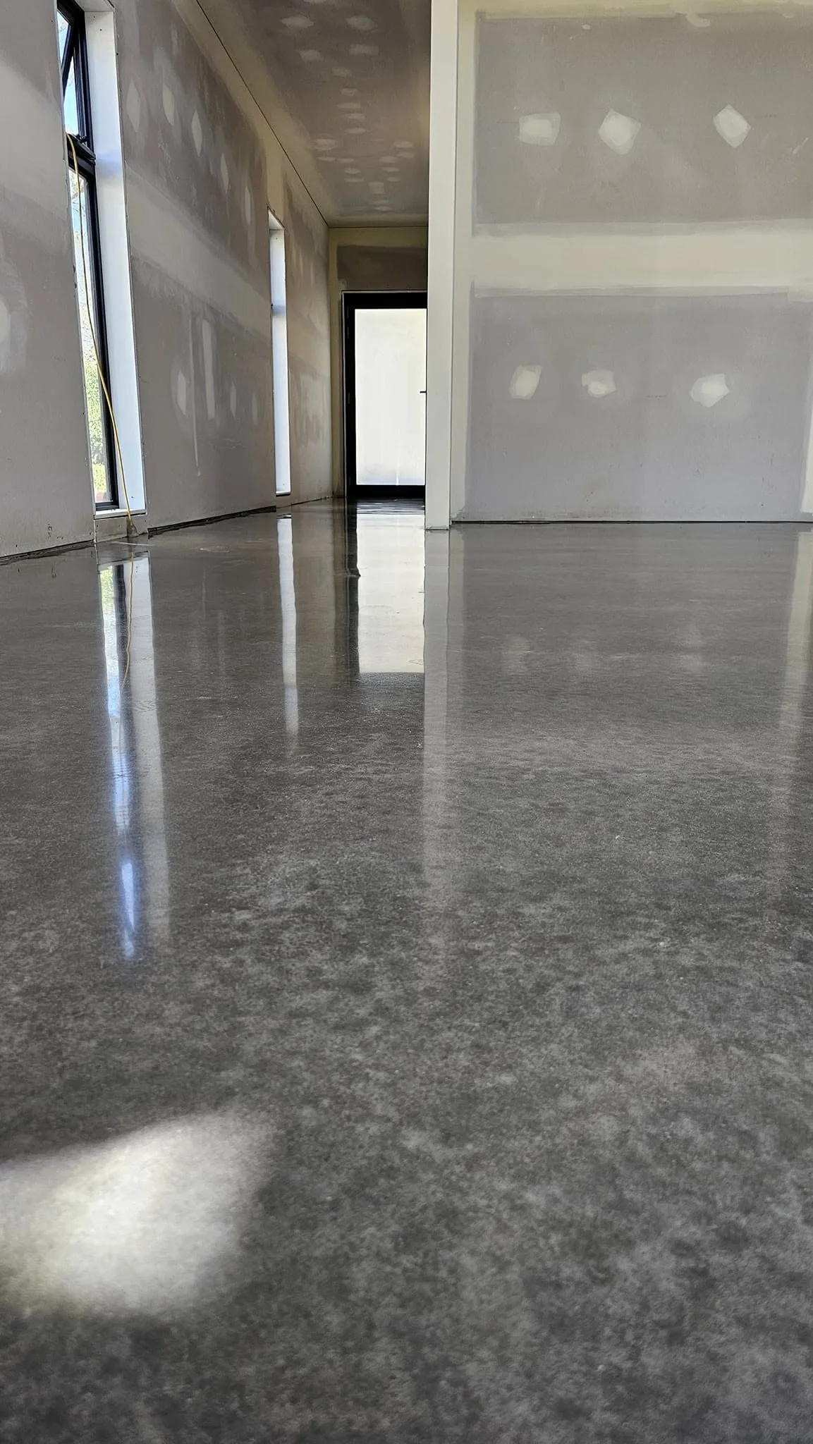 High-gloss polished concrete reflecting light down a hallway